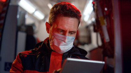 Paramedic working on digital tablet. Doctor scrolling internet pages on tablet © stockbusters