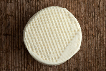 A head of brined feta cheese on a wooden background