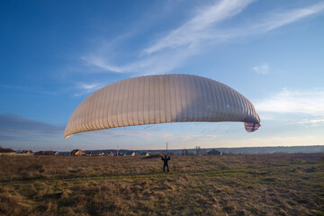 Man with paraglider training alone in park