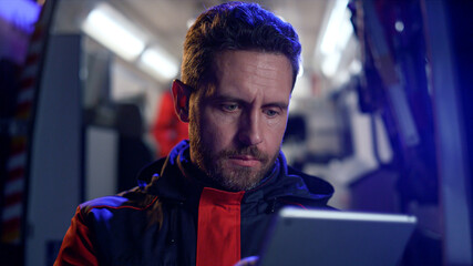 Paramedic working on tablet. Man reading information online in internet on pad © stockbusters