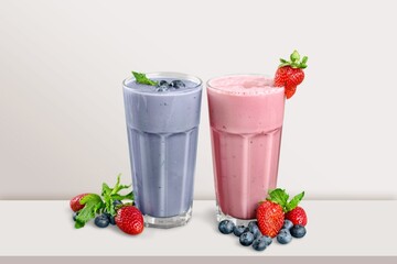 fresh milkshake with cream decorated berries portions on table.