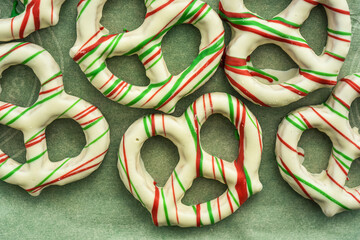 White chocolate coated pretzels decorated with red and green candy stripes Christmas holiday snack food - 474774113