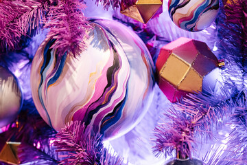 Christmas balls and glowing garlands on a purple christmas tree