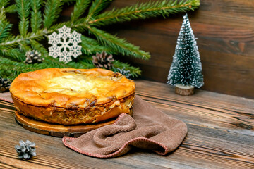 Autumn winter vegetable vegetarian food meal. homemade cabbage pie on wooden rustic table with fir spruce branches, pine cones, christmas celebration