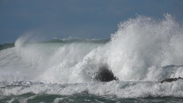 Big waves splashing.  ocean storm. Flood slow-motion. Blue sky