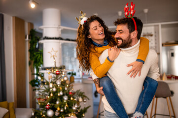 Young Caucasian love couple having fun together at home, celebrating winter h olidays together, bonding, dancing and smiling