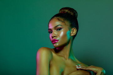 Dark skinned young woman in multicolored light. Beauty portrait of American Girl. Makeup. Fashion...