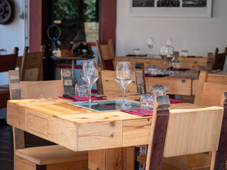Empty Wooden Tables with Crystal Wine tasting Glasses Set for Outdoor Lunch in a Tuscan Village in Italy