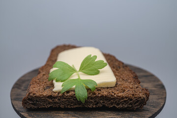 A piece of butter with herbs on toasted rye bread