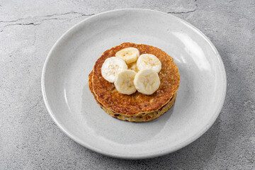 Banana oat pancakes topped with sliced ​​bananas and honey.