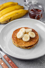Banana oat pancakes topped with sliced ​​bananas and honey.