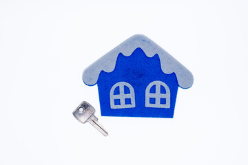 Handmade flat toy in form of house with white roof and windows on it and key