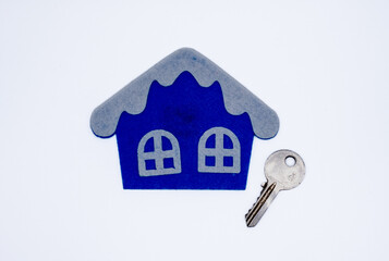 Handmade flat toy in form of house with white roof and windows on it and key