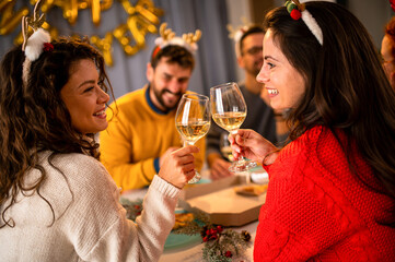 Young people celebrating a party, drink and dance . Group of friend toasting drinks while having fun at the disco club at night . Friendship and nightlife concept .