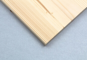 White pine plank, turned down, in the shape of a triangle, on a gray background.
