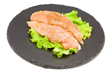 marinated raw chicken fillet on black stone plate isolated on white background. clipping path