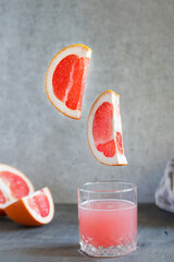 Glass of grapefruit juice on black surface