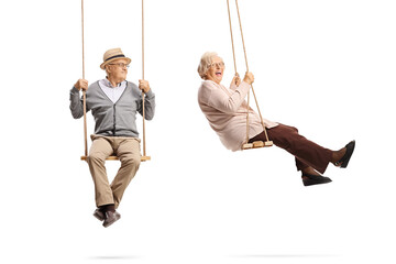 Full length shot of elderly man and woman on wooden swings