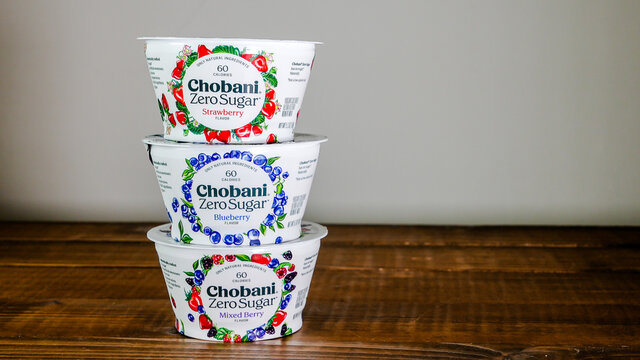 Chobani yogurts  on  wooden table with white background