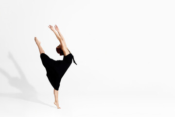 Fototapeta premium Caucasian ballerina in dress dancing in studio