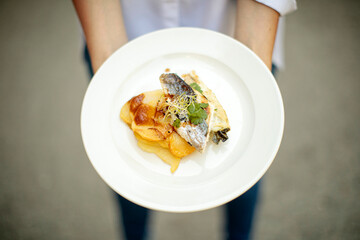 hands holding a plate of food