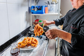 Peru Latin senior chef cooking Picarones in professional small business kitchen