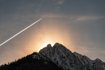 Avion volant au coucher du soleil sur les montagnes