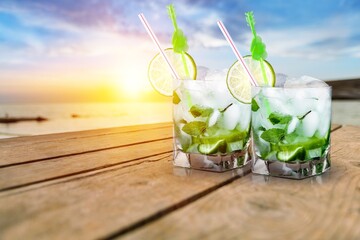 Tasty cocktail drinks with blur beach and sunset in background