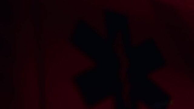 Blue and red lights flashing on ambulance at night. Emergency car with emblem