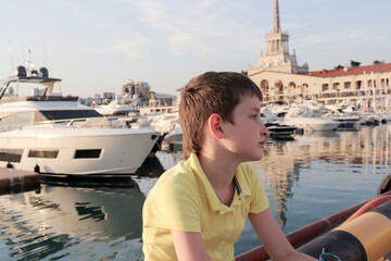 A boy is sitting on an embankment of a resort city, he is upset because all theatres and museums...