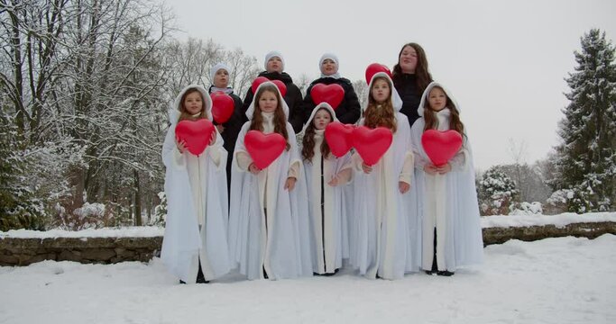 Young children together with tutor sing a song and release inflatable balloons