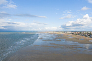 The panoramic view of the long sandy beach in Europe, France, Normandy, Ouistreham, in summer, on a sunny day.