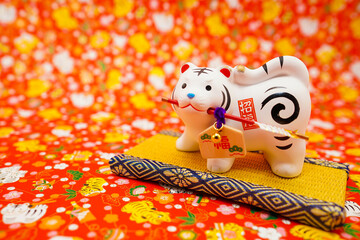 Obraz premium 寅年の人形と寅柄の背景（年賀状素材）