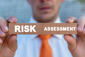 Risk Assessment Management Business Concept. Calculation Estimation Evaluation Marketing Risky Investment. Man holding wooden blocks with RISK ASSESSMENT inscription.