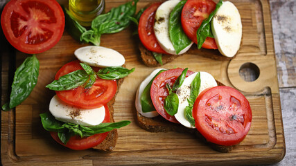 Selective focus. Caprese sandwiches on the board. Healthy snack. Italian food.
