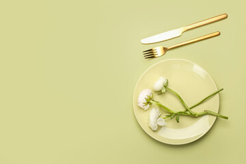 Simple table setting and ranunculus flowers on color background