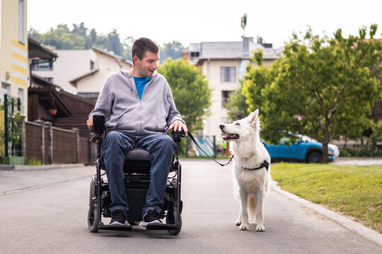 Man with disability and his service dog, a beautiful White Swiss Shepherd.