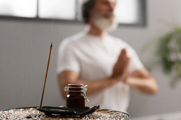 Incense stick and essential oil on table of meditating man - obrazy, fototapety, plakaty
