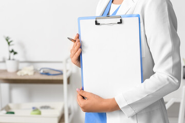 Female doctor with clipboard in medical office