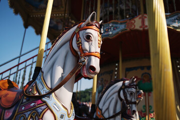 Horses on a carnival Merry Go Round. Old carousel in a holiday park.