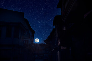 Full moon over the city at night, Turkey. Big full moon shining bright over buildings