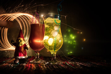 Different tasty cocktails with creative New Year holiday artwork decoration on background. Colorful cocktail in glass. Party club entertainment. Copy space.
