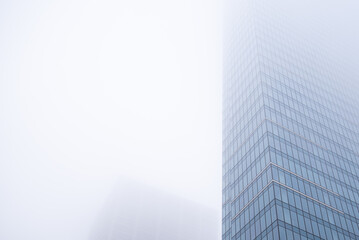 Business center in the tower skyscraper in the financial downtown center of the city in the foggy misty day with cover by clouds tops. Financial business abstract architecture concept.