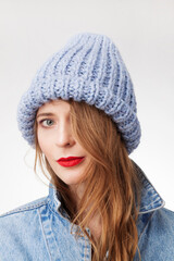 Beautiful woman in warm knit hat against white background