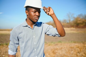 African American worker in a construction helmet