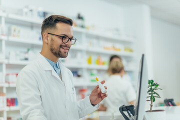 Male pharmacist holding nose spray while working at a pharmacy