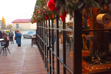 New Year's or Christmas decoration street cafe with light bulbs and trees. Christmas background