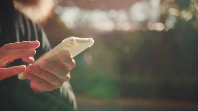 外でスマホを操作する人