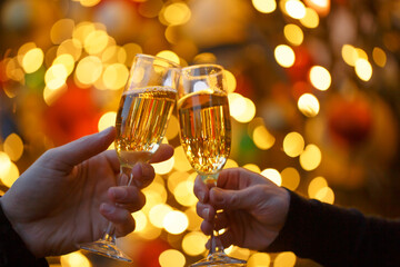 Two hands with glasses of champagne on a Christmas or New Year background