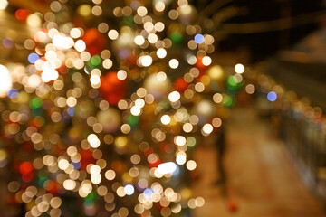 New Year's or Christmas background with light bulbs and trees. Bokeh or blur background